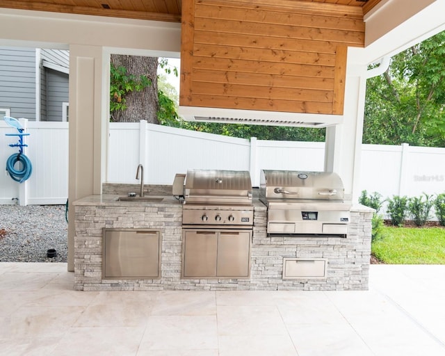 view of patio / terrace with area for grilling, a grill, and sink