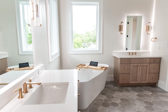 bathroom featuring a tub to relax in, a wealth of natural light, and vanity