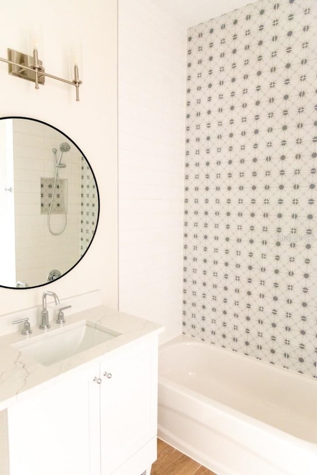 bathroom featuring shower / bathing tub combination, hardwood / wood-style floors, and vanity