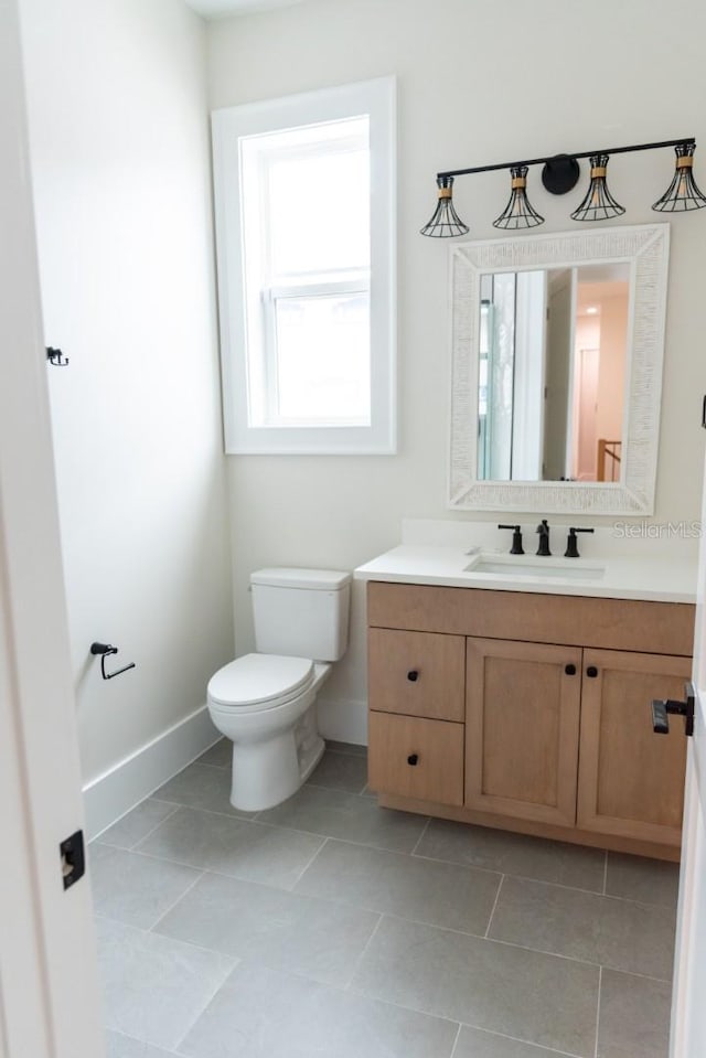 bathroom with tile patterned flooring, vanity, and toilet