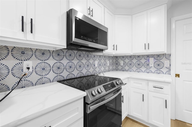 kitchen featuring light stone countertops, appliances with stainless steel finishes, and white cabinetry