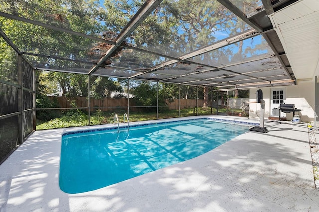 view of pool featuring glass enclosure and a patio