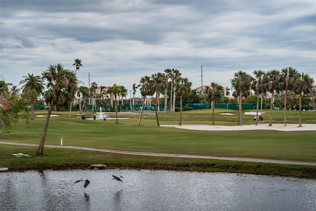 view of home's community with a water view and a lawn