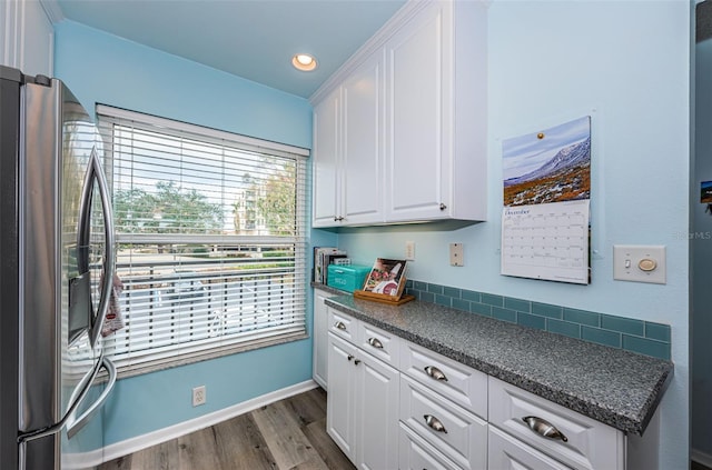 kitchen featuring white cabinets, stainless steel fridge, dark hardwood / wood-style flooring, and a wealth of natural light