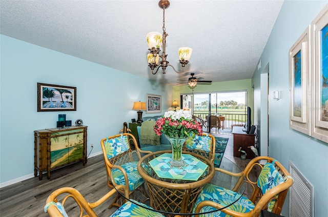 dining space featuring ceiling fan with notable chandelier, dark hardwood / wood-style flooring, and a textured ceiling