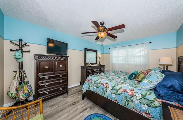 bedroom featuring ceiling fan, a textured ceiling, and light wood-type flooring