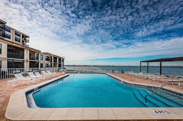 view of swimming pool with a water view and a patio area