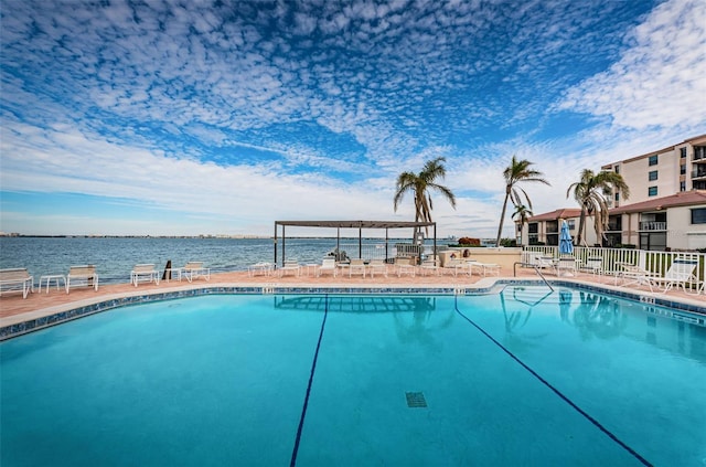 view of pool featuring a patio and a water view