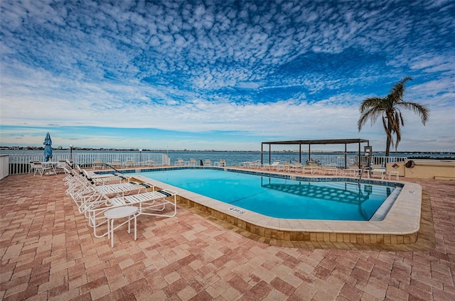 view of swimming pool featuring a patio area and a water view