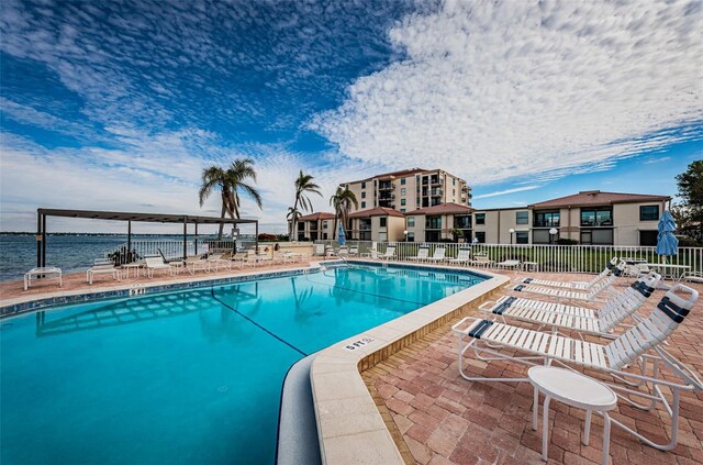 view of swimming pool with a water view and a patio