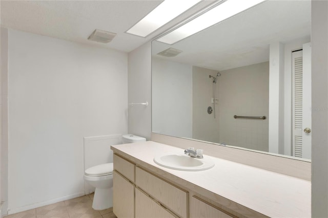 bathroom featuring walk in shower, vanity, tile patterned flooring, and toilet