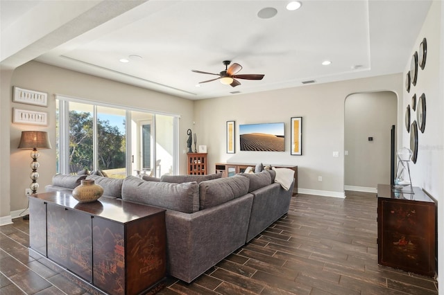 living room with ceiling fan and dark wood-type flooring