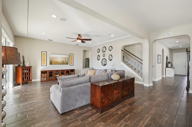 living room with ceiling fan and dark wood-type flooring