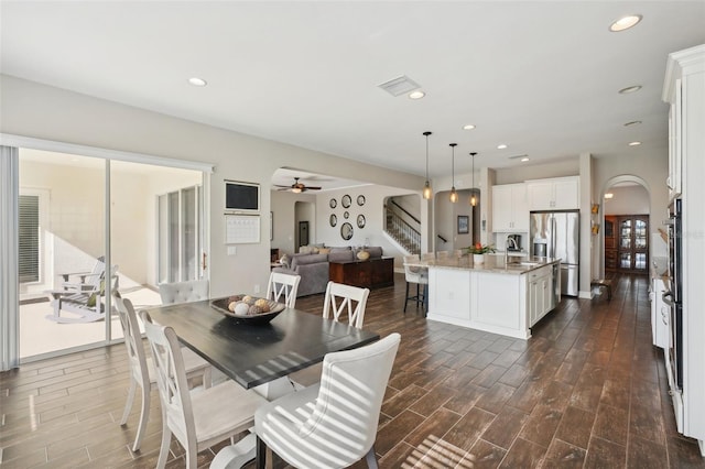 dining space with ceiling fan and dark wood-type flooring