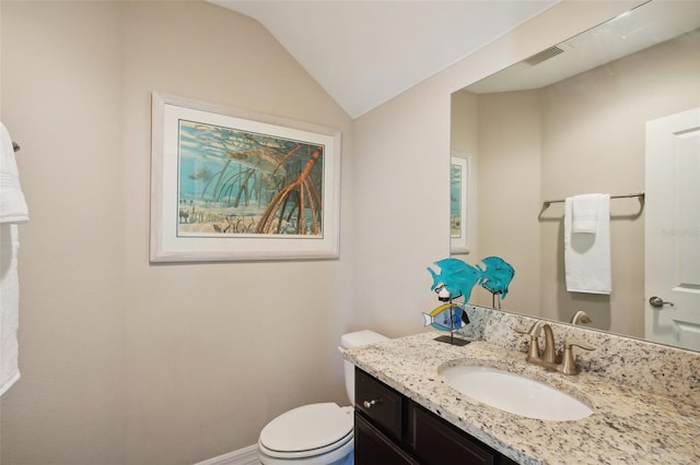 bathroom featuring vanity, toilet, and lofted ceiling