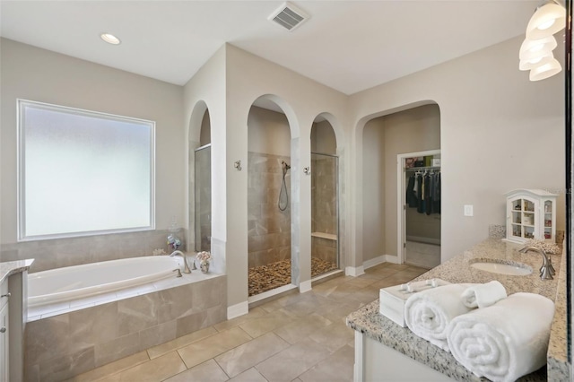 bathroom featuring tile patterned flooring, vanity, and shower with separate bathtub