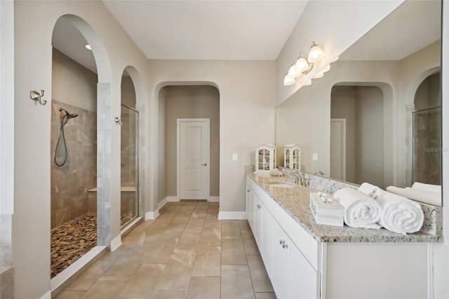 bathroom featuring tiled shower, vanity, and tile patterned floors