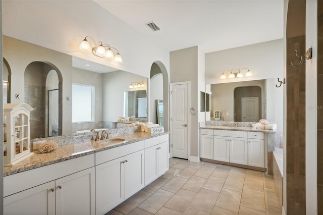 bathroom with tiled shower, vanity, and tile patterned floors