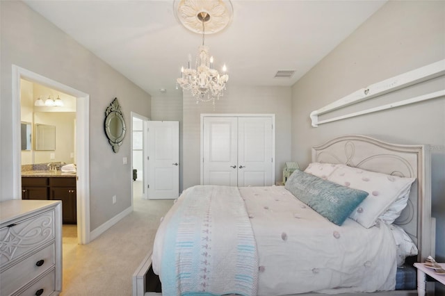 carpeted bedroom with ensuite bath, a closet, a chandelier, and sink