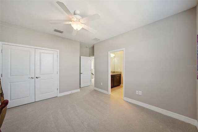 unfurnished bedroom featuring ensuite bath, ceiling fan, a closet, and light carpet