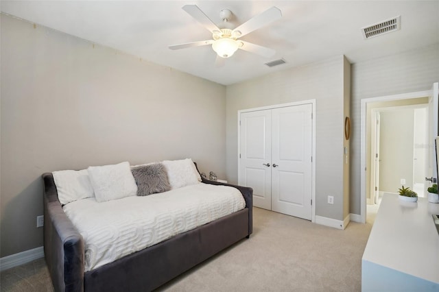 carpeted bedroom with ceiling fan and a closet