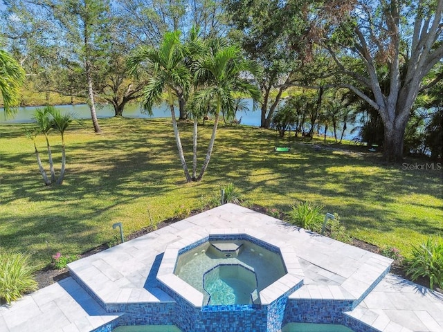 view of swimming pool featuring an in ground hot tub and a lawn