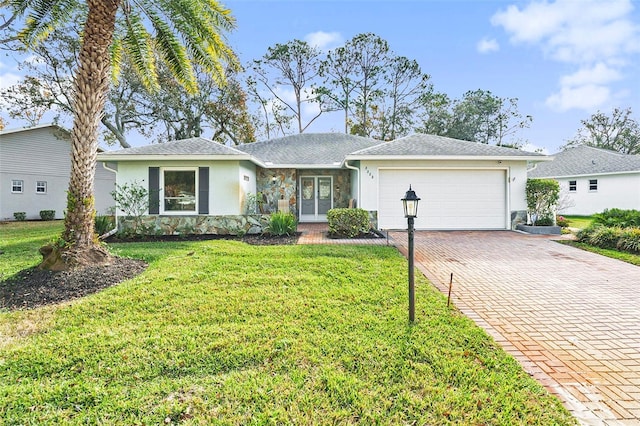 ranch-style house featuring a garage and a front lawn