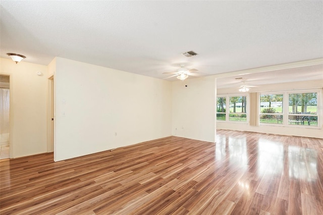 empty room featuring wood-type flooring, a textured ceiling, and ceiling fan