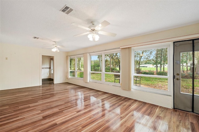 interior space with a textured ceiling, hardwood / wood-style flooring, and ceiling fan