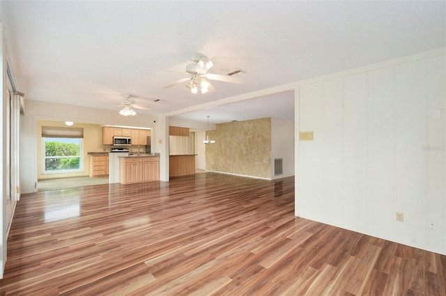 unfurnished living room featuring hardwood / wood-style flooring and ceiling fan