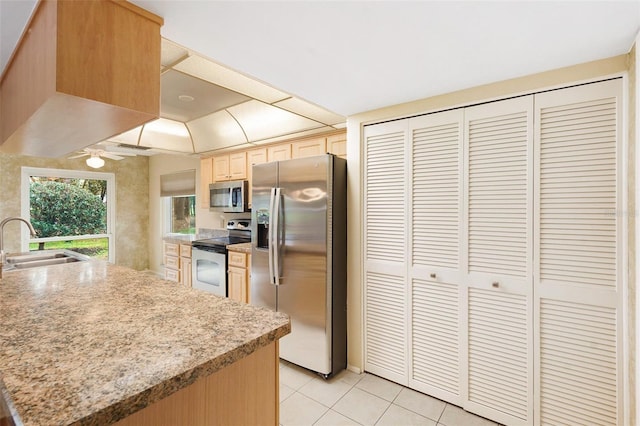 kitchen featuring ceiling fan, sink, light brown cabinets, stainless steel appliances, and light tile patterned floors