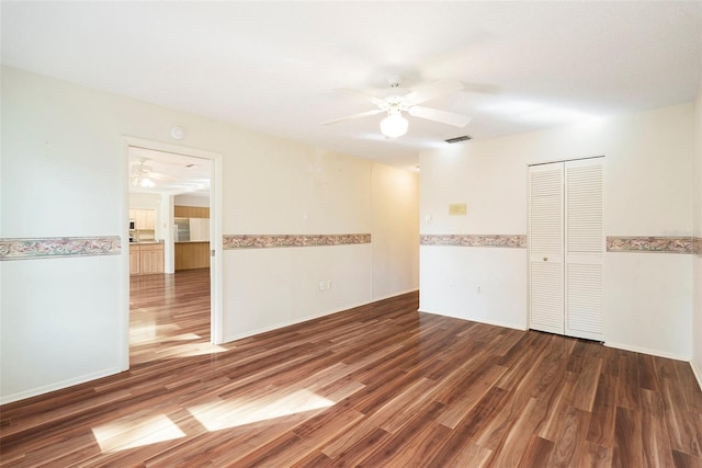 empty room featuring ceiling fan and dark wood-type flooring