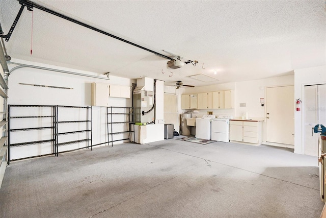 garage featuring heating unit, ceiling fan, washer and dryer, and a garage door opener