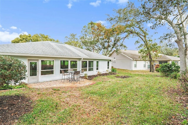 rear view of house featuring a lawn and a patio