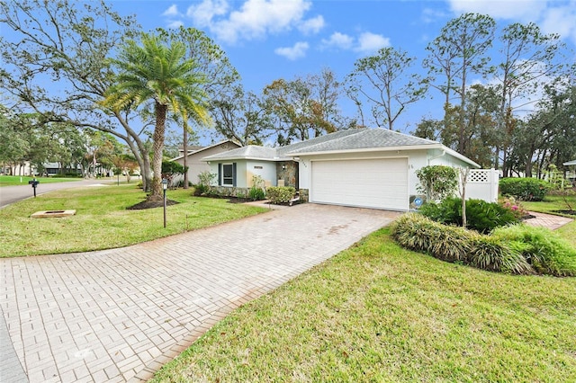 ranch-style house featuring a garage and a front lawn