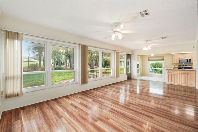 unfurnished sunroom featuring ceiling fan