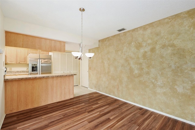 kitchen featuring kitchen peninsula, stainless steel refrigerator with ice dispenser, light brown cabinets, and light hardwood / wood-style flooring