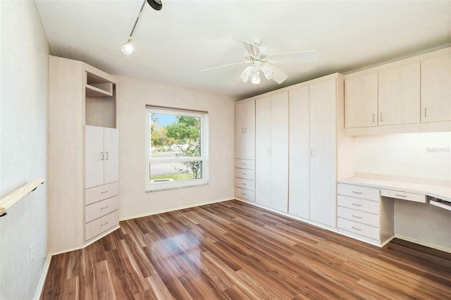 unfurnished bedroom featuring ceiling fan, dark wood-type flooring, and built in desk