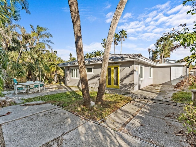 35 Juniper Way, Clearwater Beach, FL 33767 - view of front of home featuring a patio, stucco siding, and a tile roof