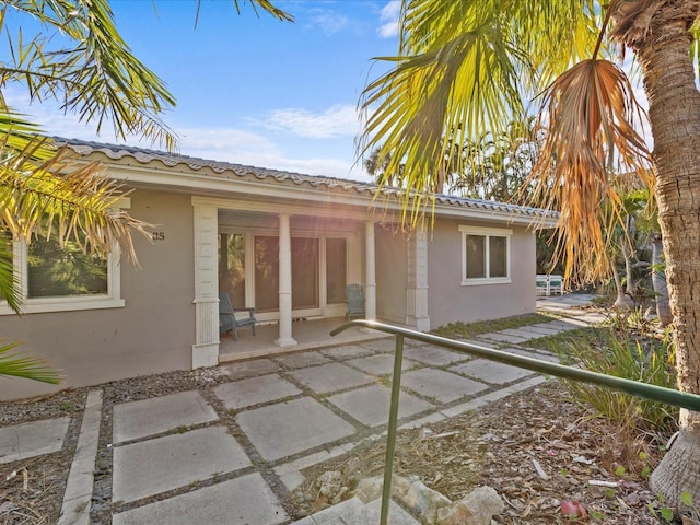 35 Juniper Way, Clearwater Beach, FL 33767 - back of property featuring stucco siding, a tile roof, and a patio