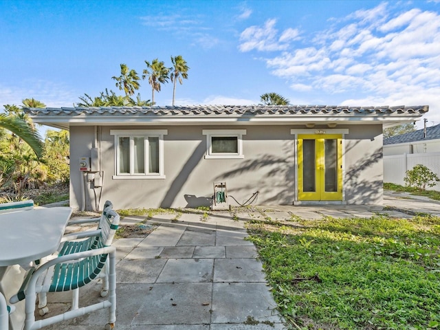 35 Juniper Way, Clearwater Beach, FL 33767 - rear view of property with stucco siding, a patio area, and a tiled roof