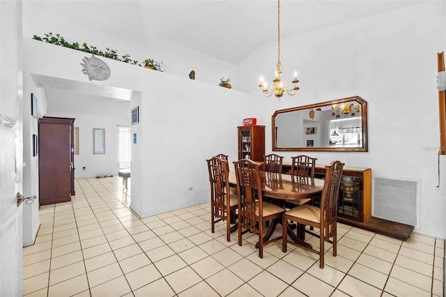 tiled dining room with high vaulted ceiling and an inviting chandelier