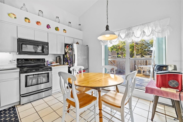 kitchen with appliances with stainless steel finishes, light tile patterned floors, decorative light fixtures, high vaulted ceiling, and white cabinetry