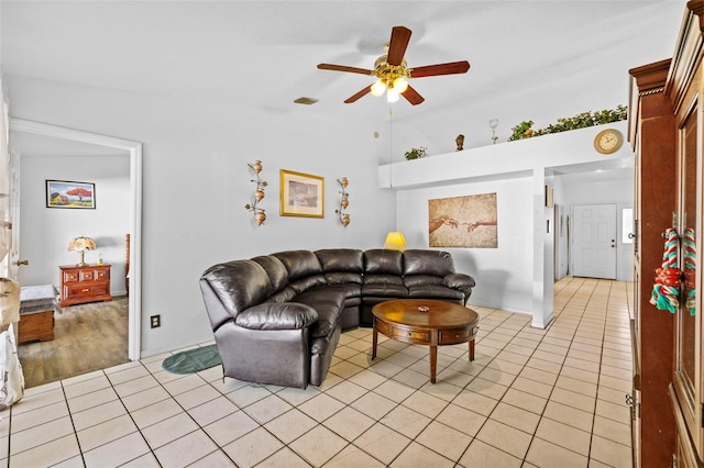 tiled living room featuring ceiling fan and vaulted ceiling