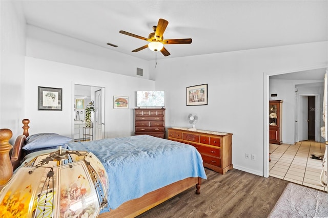 bedroom with ensuite bath, ceiling fan, and hardwood / wood-style floors