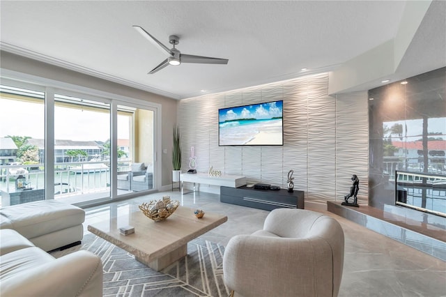 living room featuring ceiling fan, ornamental molding, and a textured ceiling