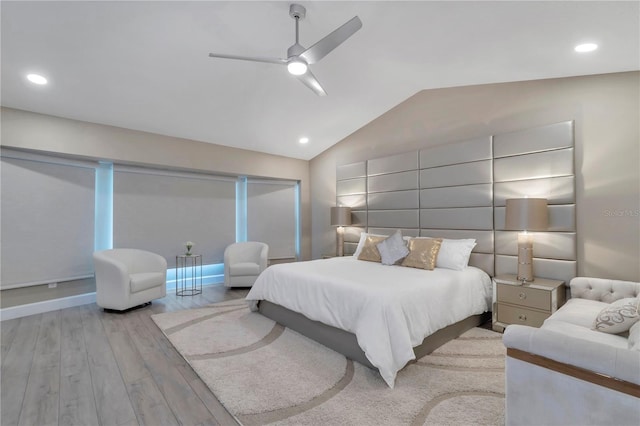 bedroom with ceiling fan, light hardwood / wood-style flooring, and vaulted ceiling