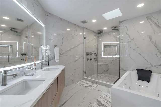 bathroom featuring shower with separate bathtub, vanity, a skylight, and tile walls