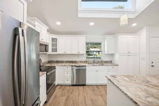 kitchen with white cabinetry, sink, hanging light fixtures, appliances with stainless steel finishes, and light wood-type flooring