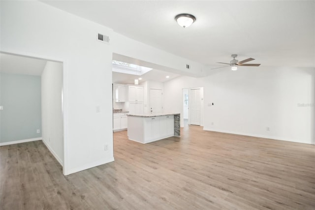 unfurnished living room featuring ceiling fan, lofted ceiling, and light hardwood / wood-style flooring